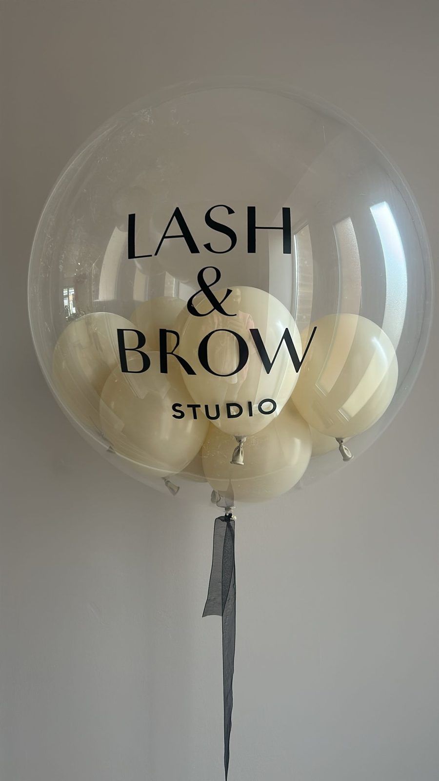 Clear balloon printed with the Lash & Brow Studio logo